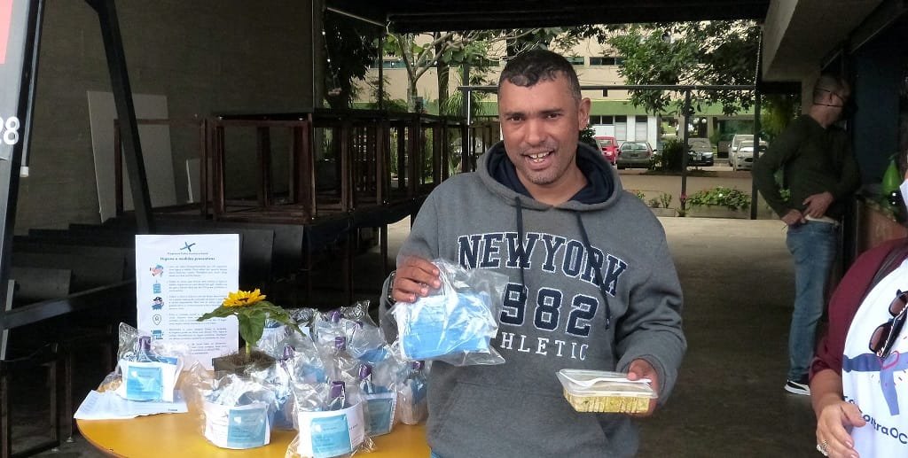 Um dos 200 motoboys exibe um kit de proteção contra o coronavírus e uma quentinha oferecido por dois restaurantes/Vinicius de Melo/Agência Brasília