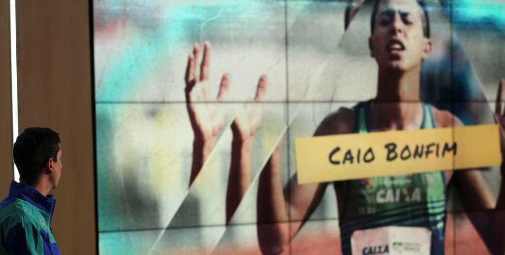 Caio Bonfim olha para a tela com sua imagem durante entrevista sobre a sua vida de atleta/Marcello Casal Júnior/Agência Brasil