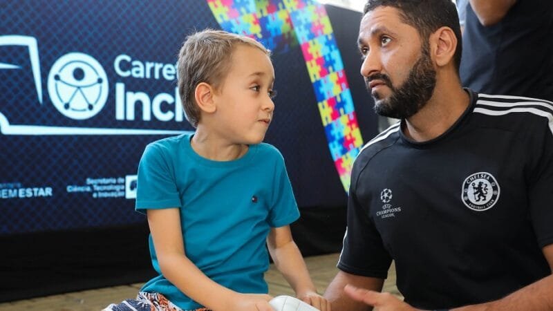 Leandro Aislan com o filho Marcelo se divertem na programação na programação da Carreta da Inclusão/Paulo H. Carvalho/Agência Brasília