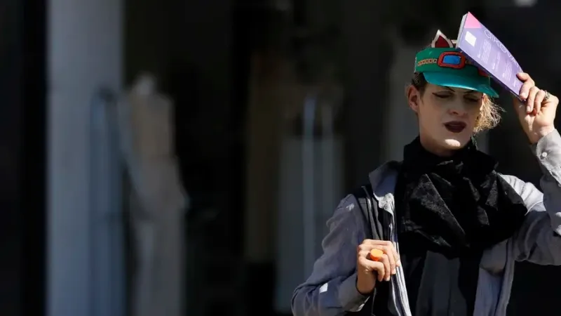 Pedestre se protege do Sol no calor intenso na rua do centro da cidade do Rio de Jeneiro/Fernando Frazão/Agência Brasil