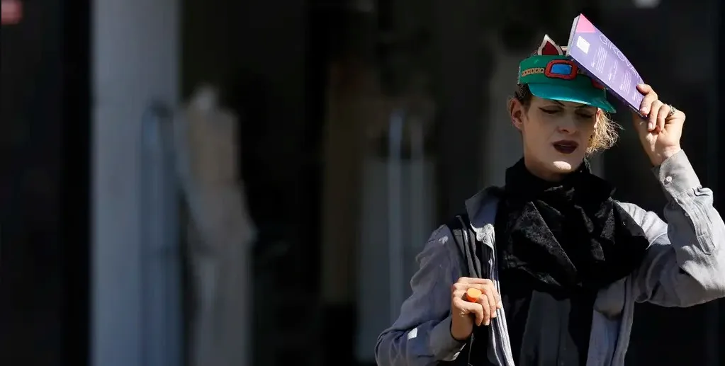 Pedestre se protege do Sol no calor intenso na rua do centro da cidade do Rio de Jeneiro/Fernando Frazão/Agência Brasil