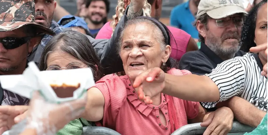 Populares disputam pedaços de bolo no bairro do Bixiga, em São Paulo, que comemorou 472 anos/Paulo Pinto;Agência Brasil