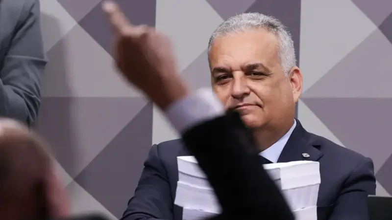 Alfredo Gaspar, relator da CPMI do INSS, observa discurso de colega com a pilha do relatório que pediu o indiciamento de 216 pessoas/Lula Marques/Agência Brasil