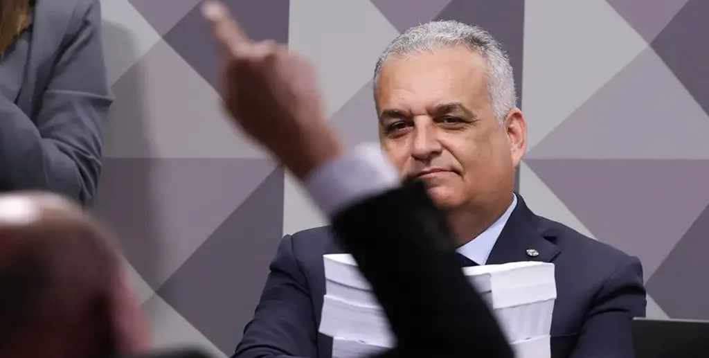 Alfredo Gaspar, relator da CPMI do INSS, observa discurso de colega com a pilha do relatório que pediu o indiciamento de 216 pessoas/Lula Marques/Agência Brasil
