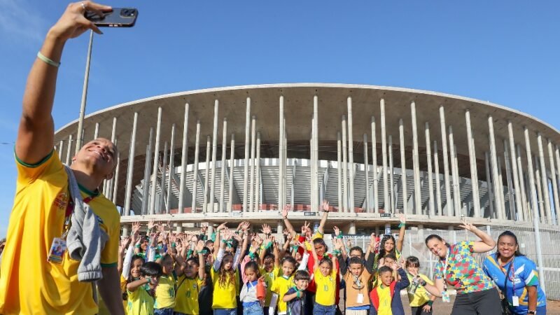 Crianças dos centros olímpicos do DF tiram selfie na frente do Mané Garrincha para a contagem regressiva da Copa Feminina de 2027/Paulo H. Carvalho/Agência Brasília