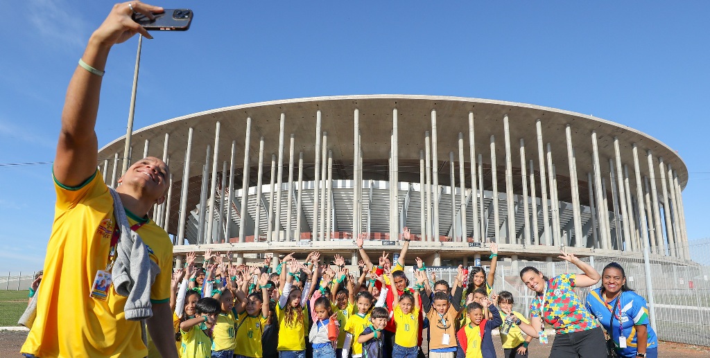 Crianças dos centros olímpicos do DF tiram selfie na frente do Mané Garrincha para a contagem regressiva da Copa Feminina de 2027/Paulo H. Carvalho/Agência Brasília