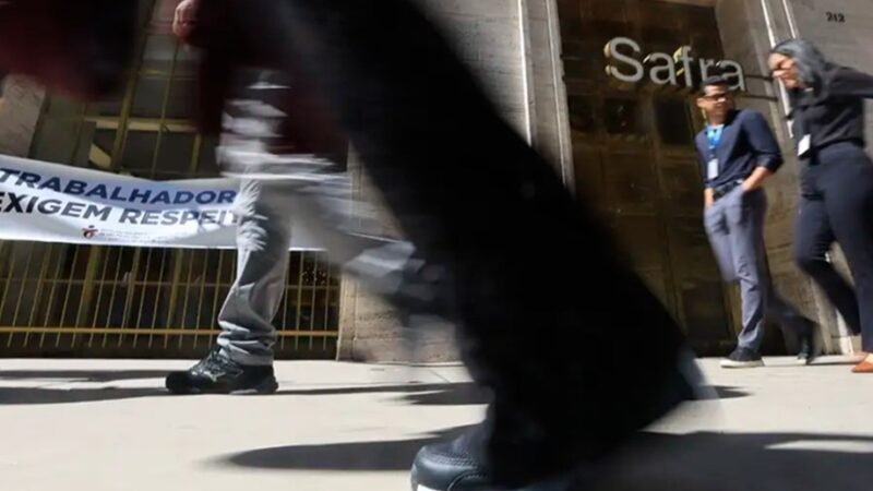 Pedestres passam apressados na frente de uma agência bancária, em São Paulo, fechada pela greve dos bancários/Paulo Pinto/Agencia Brasil