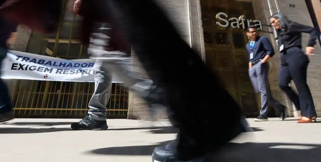 Pedestres passam apressados na frente de uma agência bancária, em São Paulo, fechada pela greve dos bancários/Paulo Pinto/Agencia Brasil