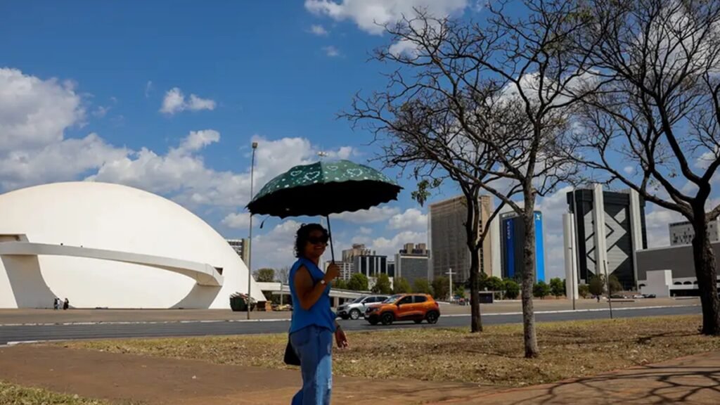 Mulher se protege com guarda-chuva do Sol em dia muito quente na zona central da capital dos brasileiros/Fabio Rodrigues-Pozzebom/Agência Brasil